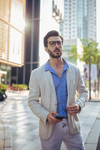 istock Man standing outdoors and holding mobile phone 858181788