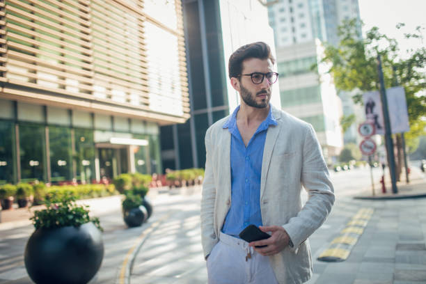 istock Man standing outdoors and holding smartphone 858182158