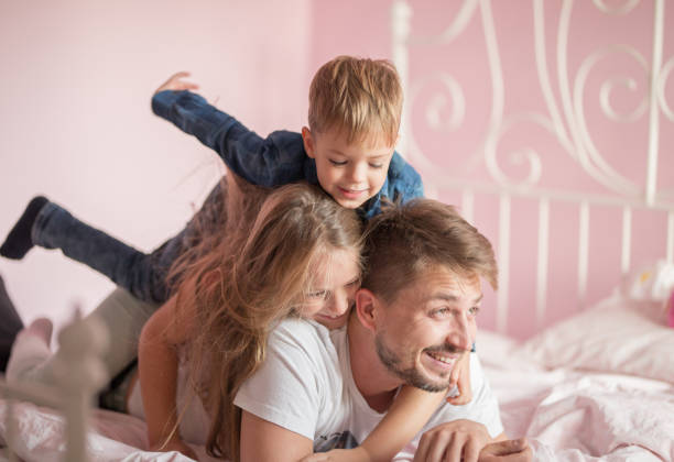 istock Father playing in bed with his children 858184764
