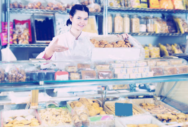 istock Seller in white uniform with dark cookies 858188580