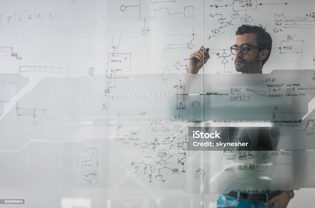 Männliche Ingenieur arbeitet an neuen Ideen und schreibt Diagramm an Glaswand. - Lizenzfrei Komplexität Stock-Foto