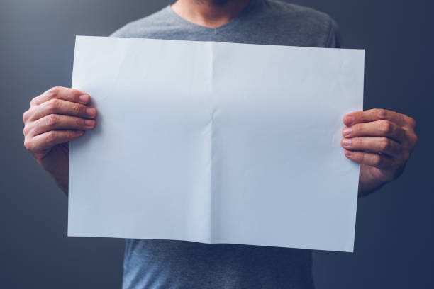istock Casual man holding blank A3 paper 858196032