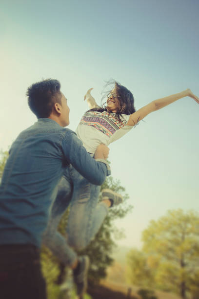 istock Young man lifting up his friend in air. 858197402