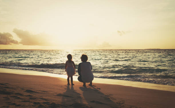 istock father and little daughter talking on sunset beach 858198340