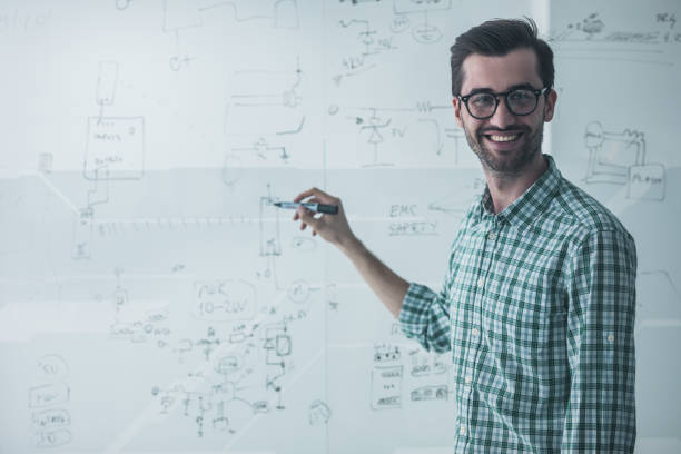 istock Happy engineer drawing a diagram on a glass in the office. 858203702