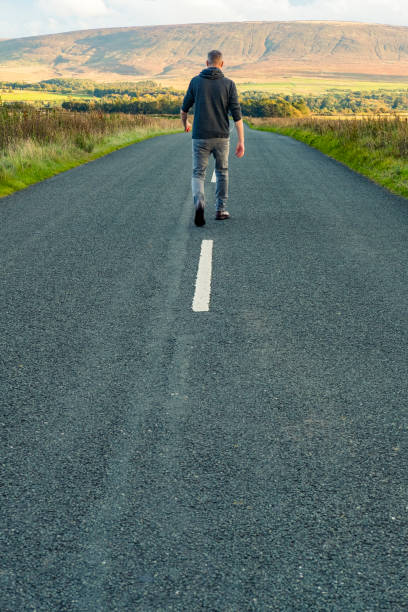 istock man walking along a country road. 858212706
