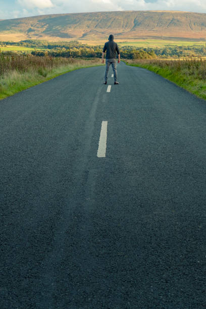 istock man walking along a country road. 858212738