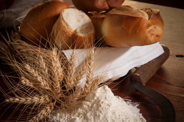 close-up of bread, wheat and flour, are shown arranged above the table with a country air.