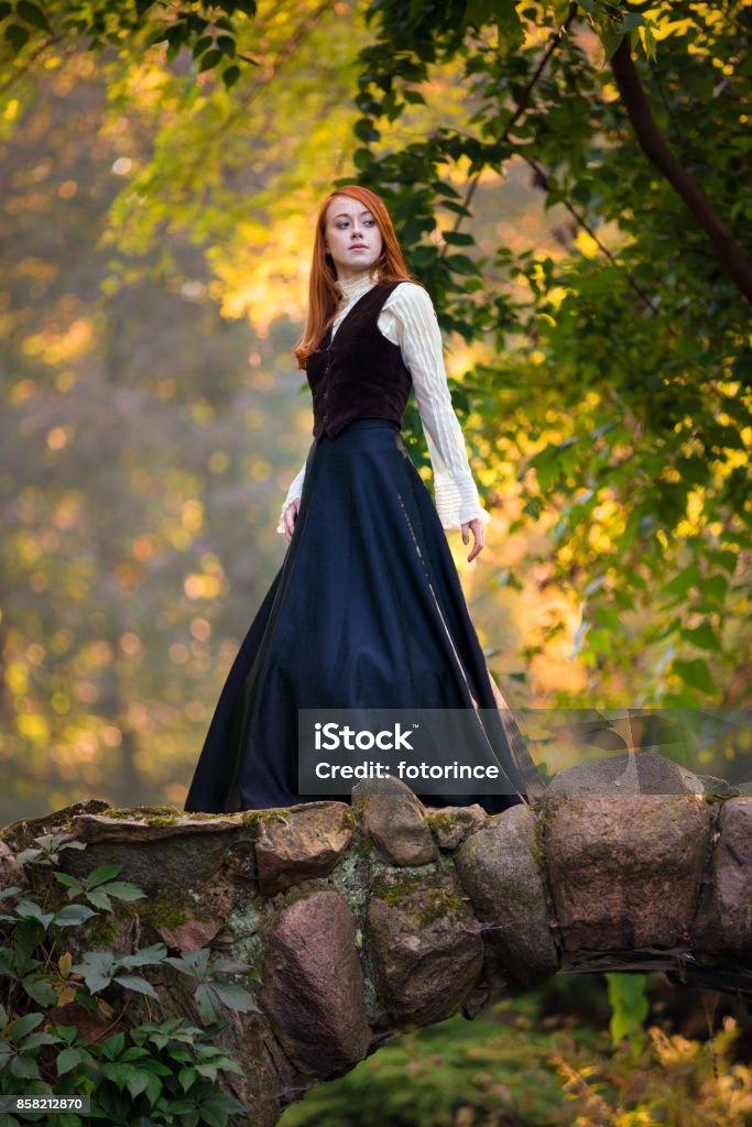 Red-haired woman in Victorian outfit with autumn park Women Stock Photo