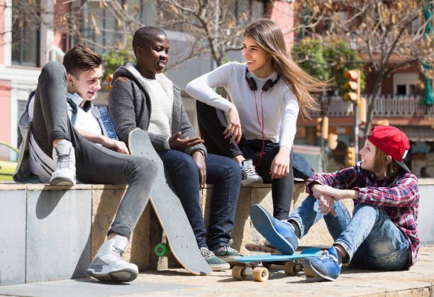 istock girl and three boys hanging out outdoors and discussing something 858215734