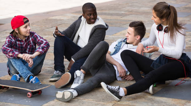 istock girl and three boys hanging out outdoors and discussing something 858215736
