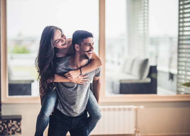 istock Playful couple having fun while piggybacking at home. 858219688