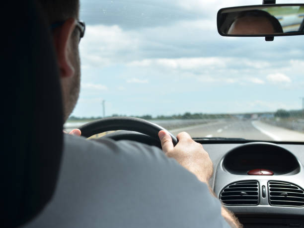 istock Man driving a car on a highway 858222700