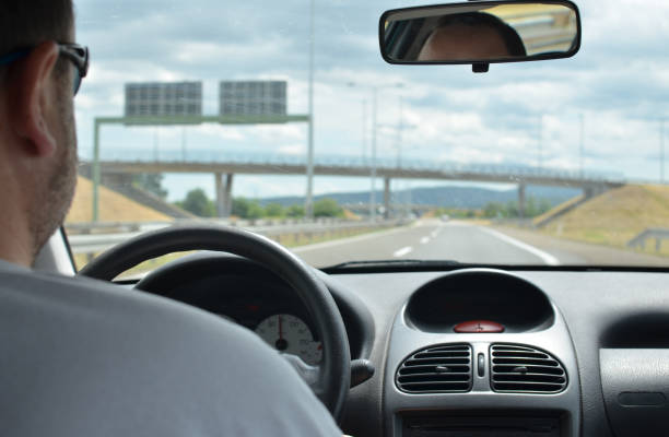 istock Man driving a car on a highway 858222904