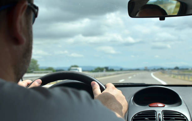istock Man driving a car on a motorway 858223080
