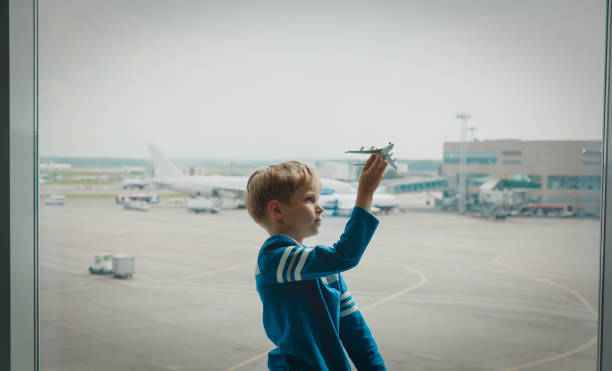 istock boy playing with toy plane while waiting in airport 858223270
