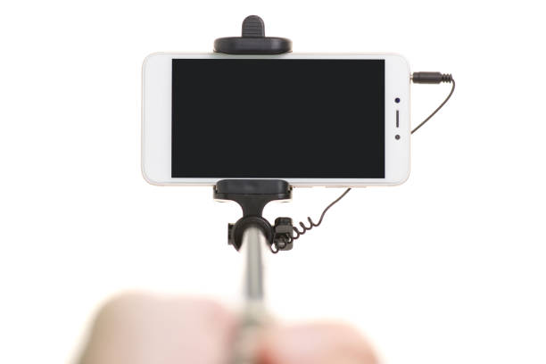 Smartphone and selfie stick in hand on white background isolation