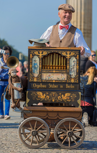 Berlin, Germany - September 17, 2014 : Man playing the hand organ for the tourists in front of the Brandenburg Gate in Berlin Germany
