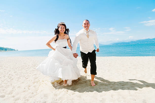 bride and groom running on the beach - young men young women bride hairstyle photos et images de collection