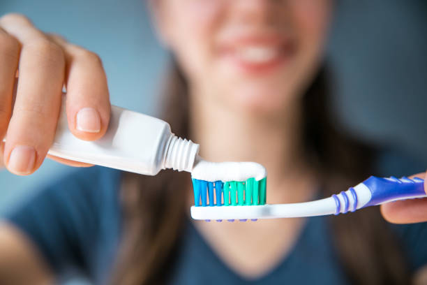 Brushing Teeth Woman, Toothbrush, Toothpaste, scrub, closeup, horizontal, background tooth in hand stock pictures, royalty-free photos & images