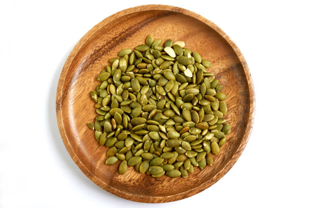 istock Pumpkin seeds in a round wooden dish. 858257172