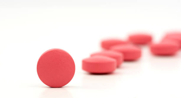 foto primer plano de rosa pastillas naranja aislada sobre fondo blanco con fondo borroso - pink pill fotografías e imágenes de stock