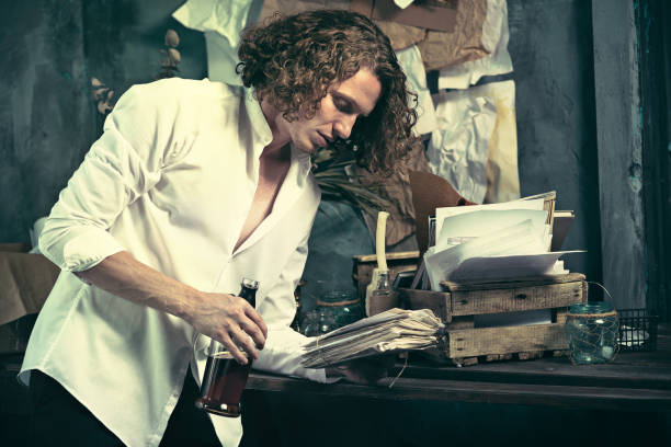 istock Writer at work. Handsome young writer standing near the table and making up something in his mind 858257294
