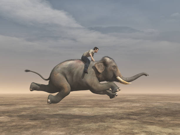 istock Surreal image of a man riding an elephant 858259840