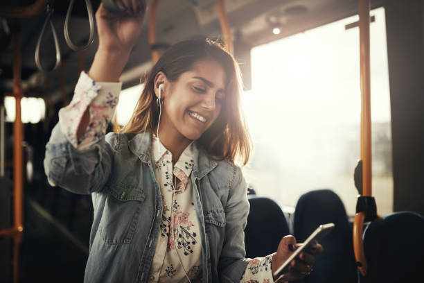 웃 고 음악을 듣고 버스를 타고 하는 젊은 여자 - public transportation audio 뉴스 사진 이미지