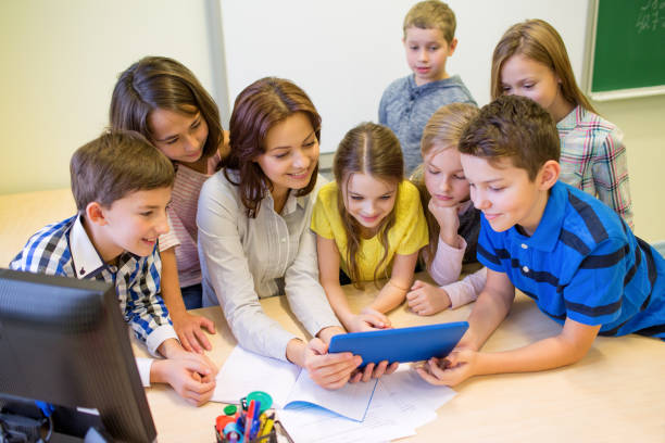 istock group of kids with teacher and tablet pc at school 858260576