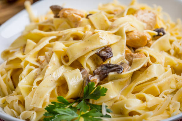Tagliatelle pasta with forest mushrooms and chicken. Small depth of field.