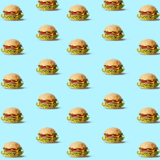 many tasty fly hamburgers on blue texture. - morning tomato lettuce vegetable imagens e fotografias de stock