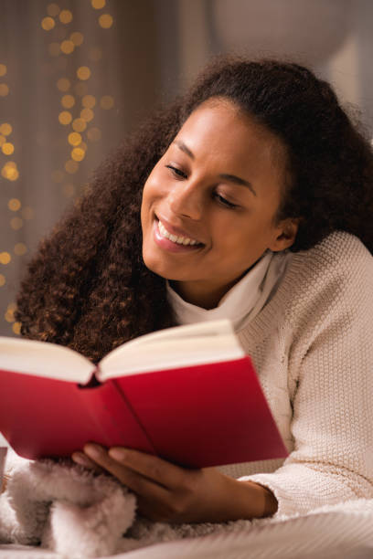 istock Woman reading a book on bed 858268574