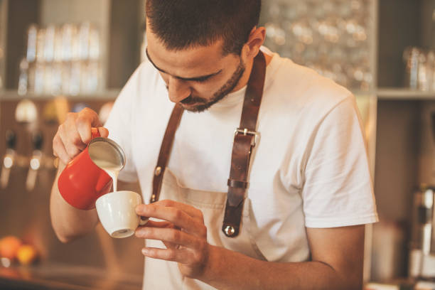 istock Barista pouring milk in coffee 858271766