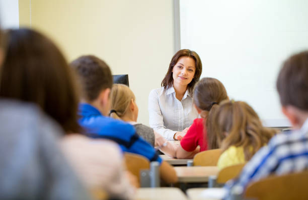 istock group of school kids raising hands in classroom 858275672