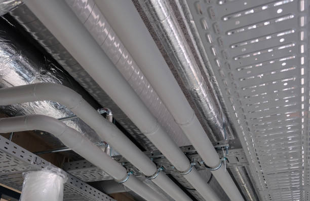 istock Heating and water cooling pipes attached to ceiling in office buidling 858275714