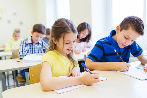 istock group of school kids writing test in classroom 858276236