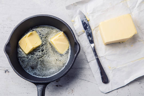 butter. stück butter in die heiße pfanne-top anzeigen - butter dairy product fat food stock-fotos und bilder
