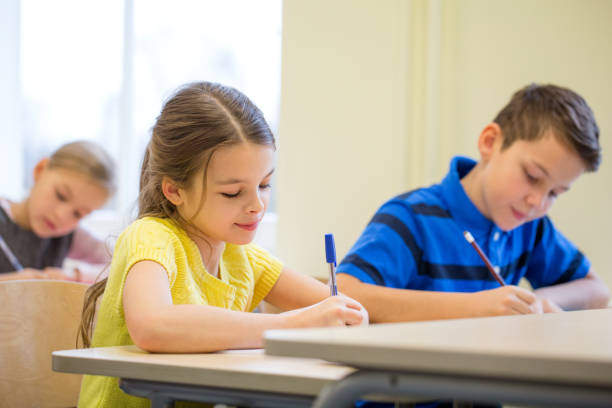 istock group of school kids writing test in classroom 858277522