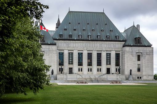The Supreme Court of Canada located on Wellington street in Ottawa, Ontario on a cloudy day of summer.