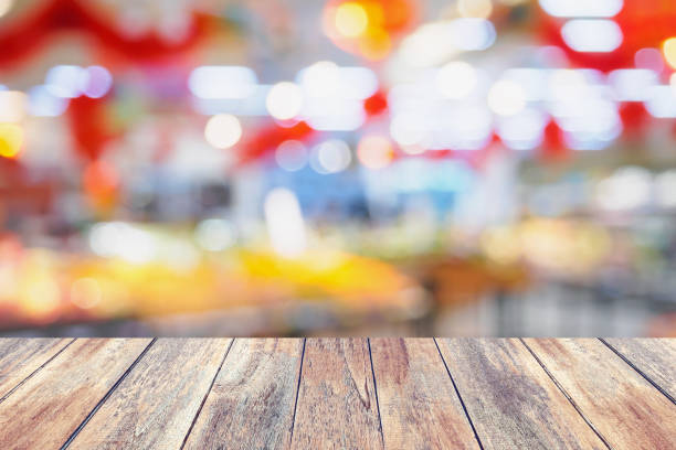 istock wood table with abstract supermarket blurred background 858285558