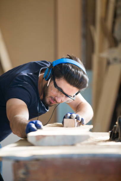 istock Young handosme carpenter blowing off sawdust 858293586