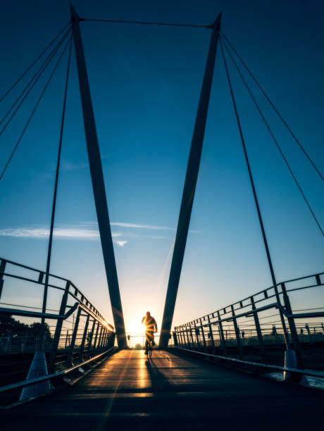istock Cyclist silhouetted by sunrise on Lancaster Millennium Bridge 858298628