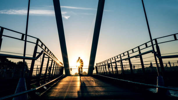 istock Cyclist silhouetted by sunrise on Lancaster Millennium Bridge 858298662