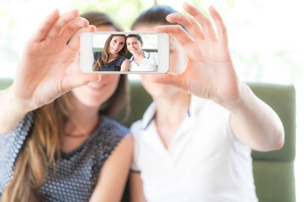 istock Friends hugging in cafe and taking selfie with smartphone 858299018