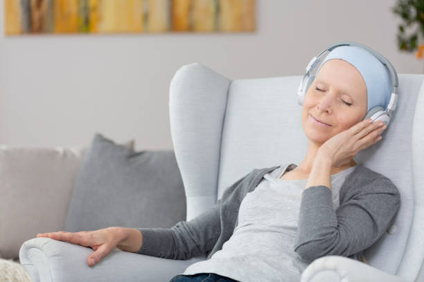 Woman with cancer in armchair stock photo