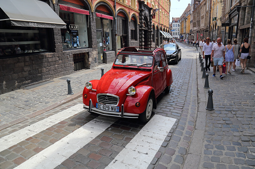 Lille, France - May 27, 2017: Red Citroen car and tourists in the Rue de la Monnaie street in the old part of Lille, France on May 27, 2017