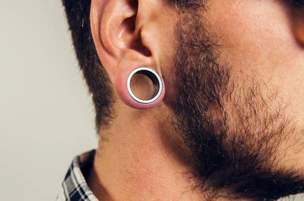 gros plan d’oreille hipster, avec boucle d’oreille de trou. - boucle doreille photos et images de collection