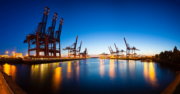 Panoramic view of a large container harbor with deep blue night sky