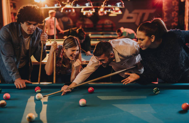 istock Group of young people cheering while playing snooker in a pool hall. 858309374